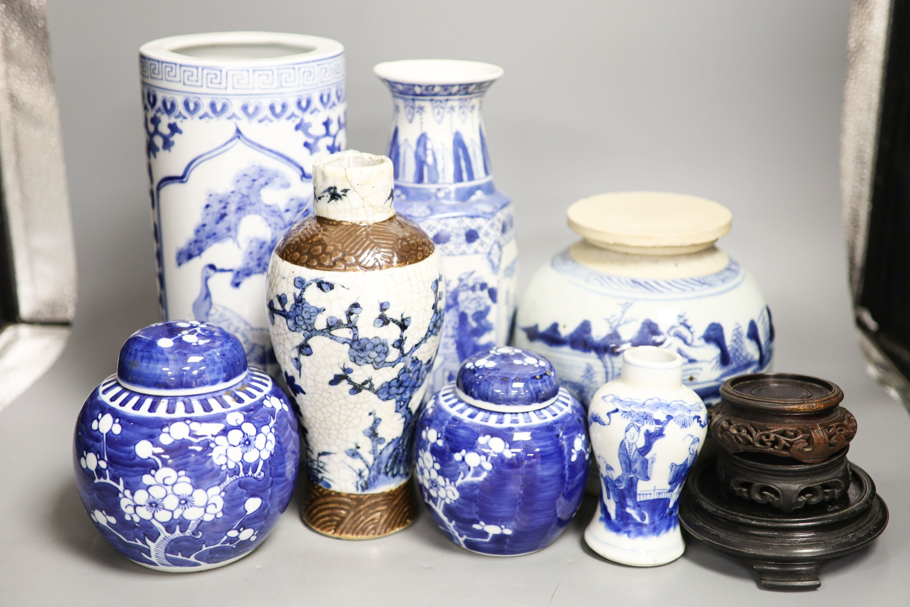 A group of seven Chinese blue and white porcelain vases and jars, 19th/20th century, and three wood stands 27cm